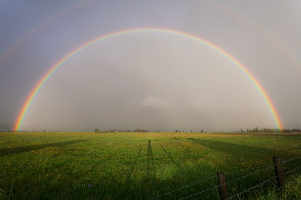 imagem de um arco-iris no campo verde